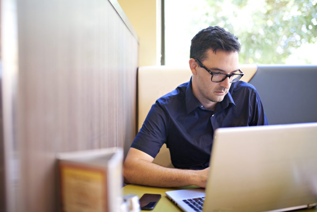 man with glasses on laptop