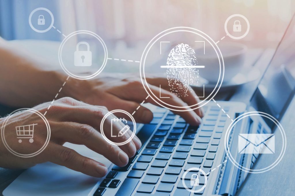 hands typing on laptop with security icons